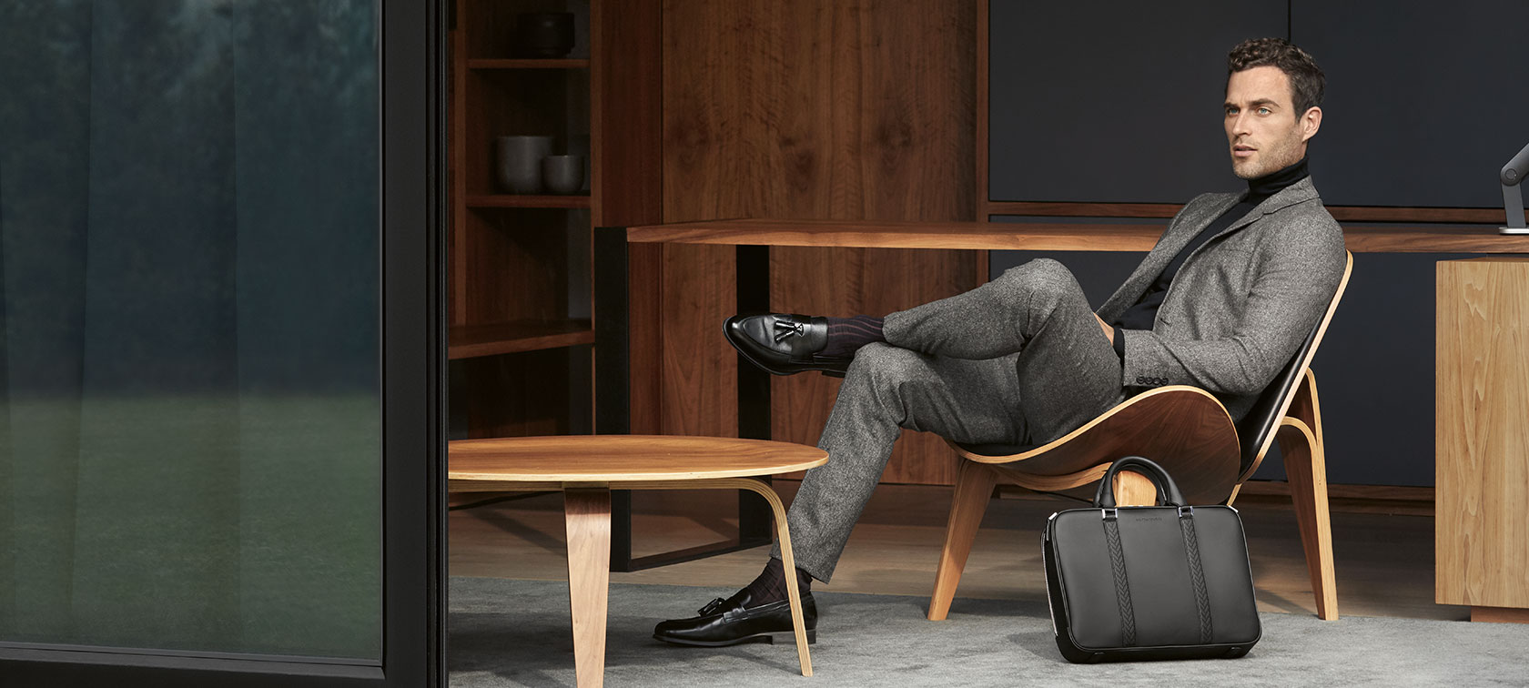 In the picture, a seated man wearing a suit presents articles from The Collection.