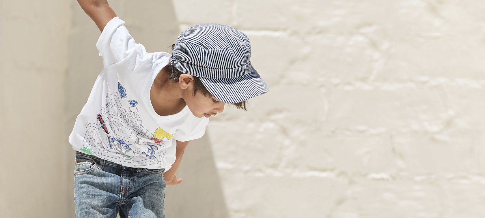 A boy looking down wears the T-shirt from the BMW Kids Collection.