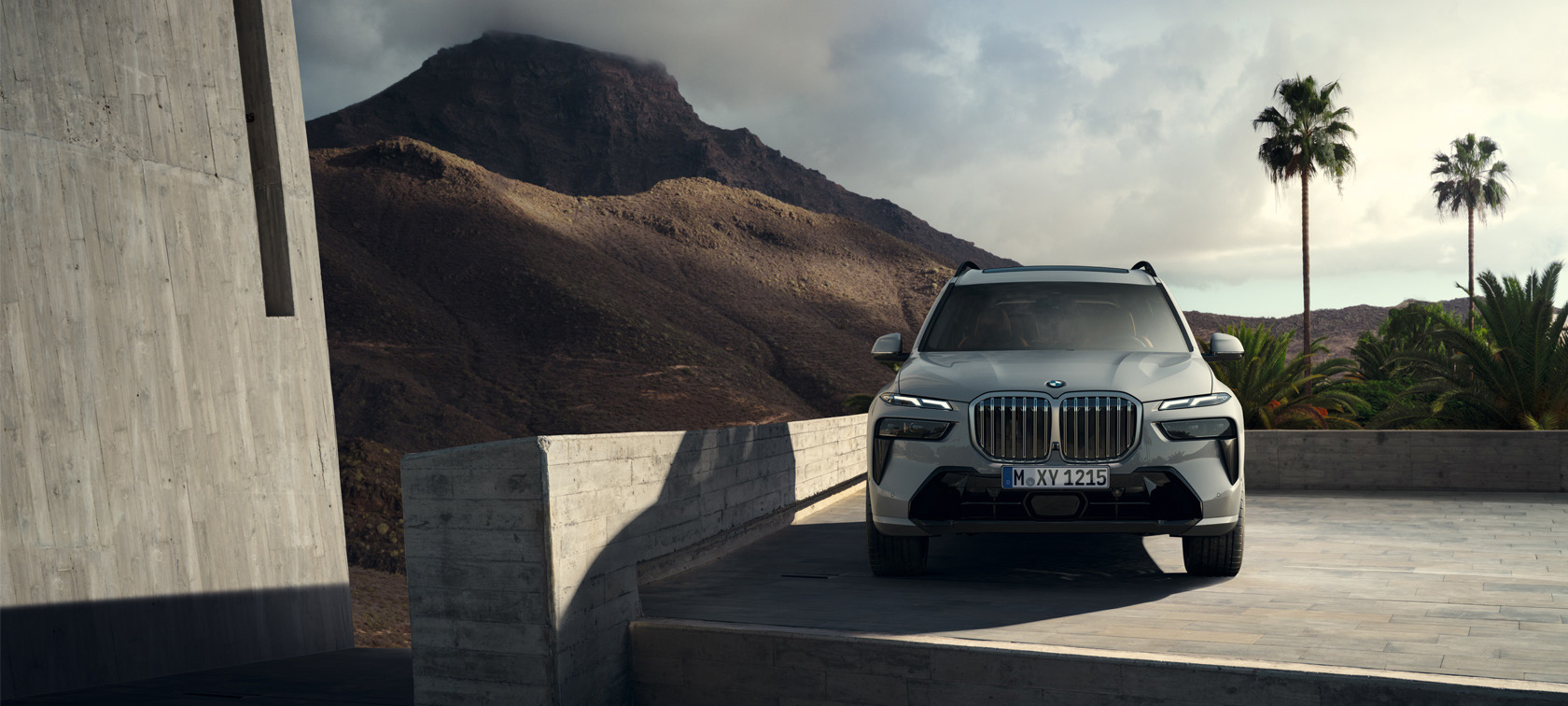 The new BMW X7 G07 LCI 7/8 Front view driving Sparkling Copper Grey metallic